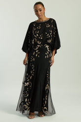 Black maxi dress with gold sequin floral embellishment, flowing sheer sleeves and full-length silhouette, Ambretta by Frock and Frill.