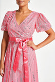 Cleo strawberry embellished wrap front dress with V neckline, satin waist tie and dip hem designed for weddings, race days and summer occasion wear styling