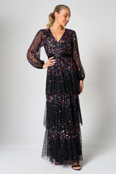 Iris black iridescent sequin maxi dress with V neckline, sheer sleeves and tiered skirt designed for elegant evening and occasion wear styling