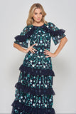 Jasmine navy maxi dress by Frock and Frill with floral embroidery, ruffled tiered skirt, and sheer flutter sleeves, styled for weddings and garden parties.