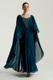 Rhea teal cape sleeve maxi dress with silver-embellished bodice, flowing cape overlay, and modest elegant silhouette for weddings and formal events.