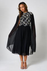 Una black embellished cape sleeve midi dress by Frock and Frill with silver bodice detailing, high neckline and flared skirt designed for elegant occasion wear styling