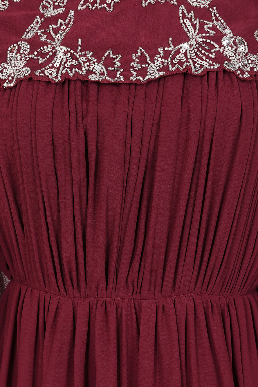 Frock & Frill Aruna burgundy embellished cape maxi dress with sparkling beaded bodice, flowing chiffon cape sleeves, and elegant full-length silhouette—ideal for weddings and formal events.