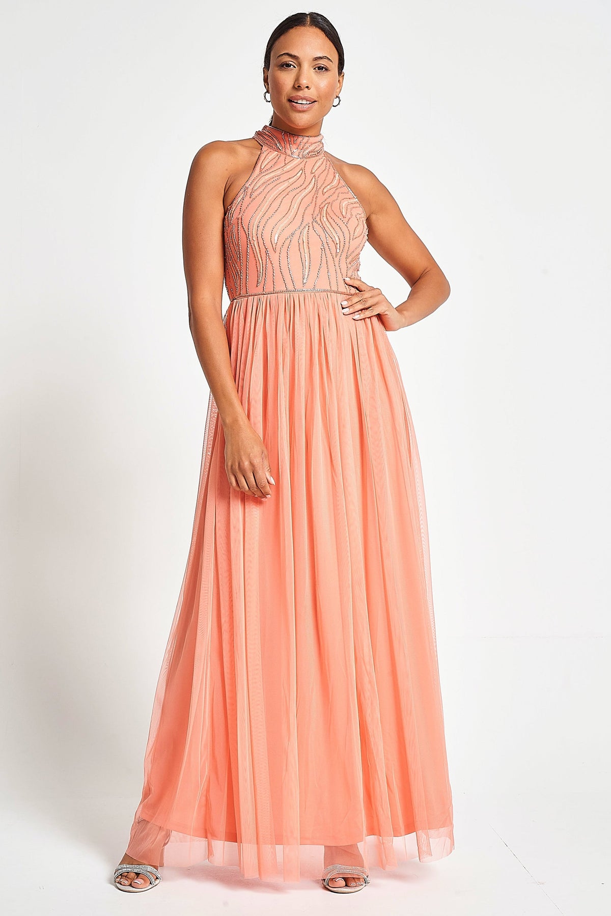 Caroline coral embellished halter neck maxi dress with intricate bead detailing and flowing full-length silhouette designed for statement occasion wear styling
