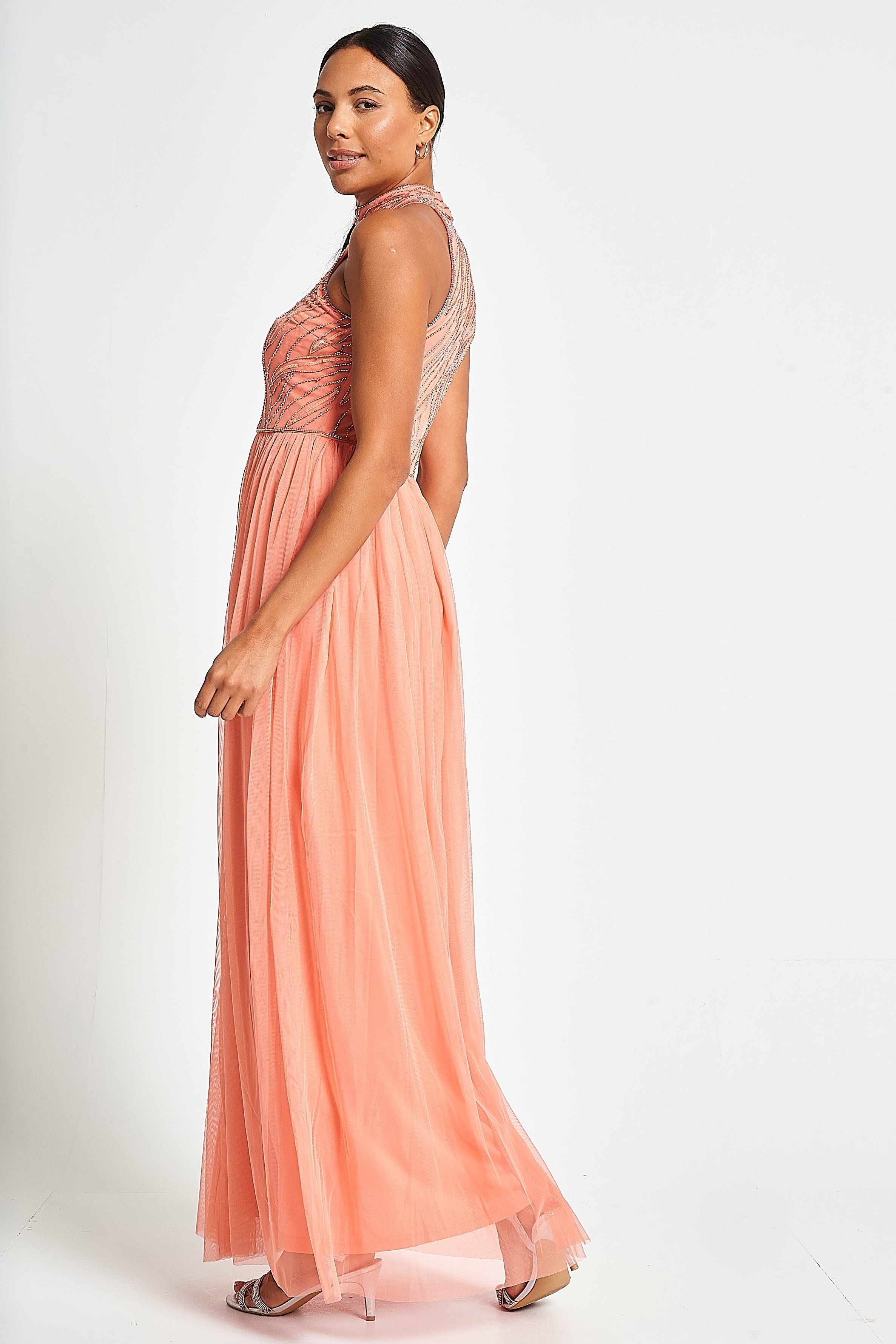 Caroline coral embellished halter neck maxi dress with intricate bead detailing and flowing full-length silhouette designed for statement occasion wear styling