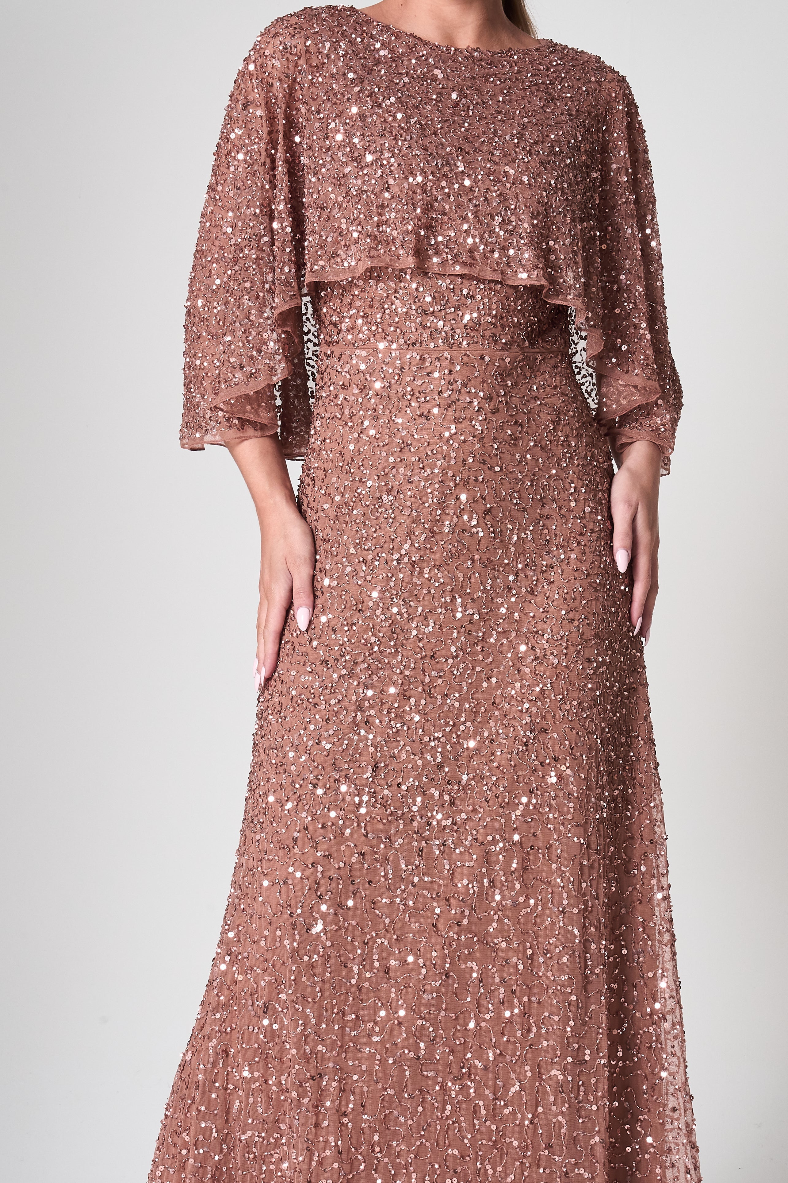 Charlotte rose gold sequin maxi dress with elegant cape overlay, round neckline, and flowing floor-length silhouette