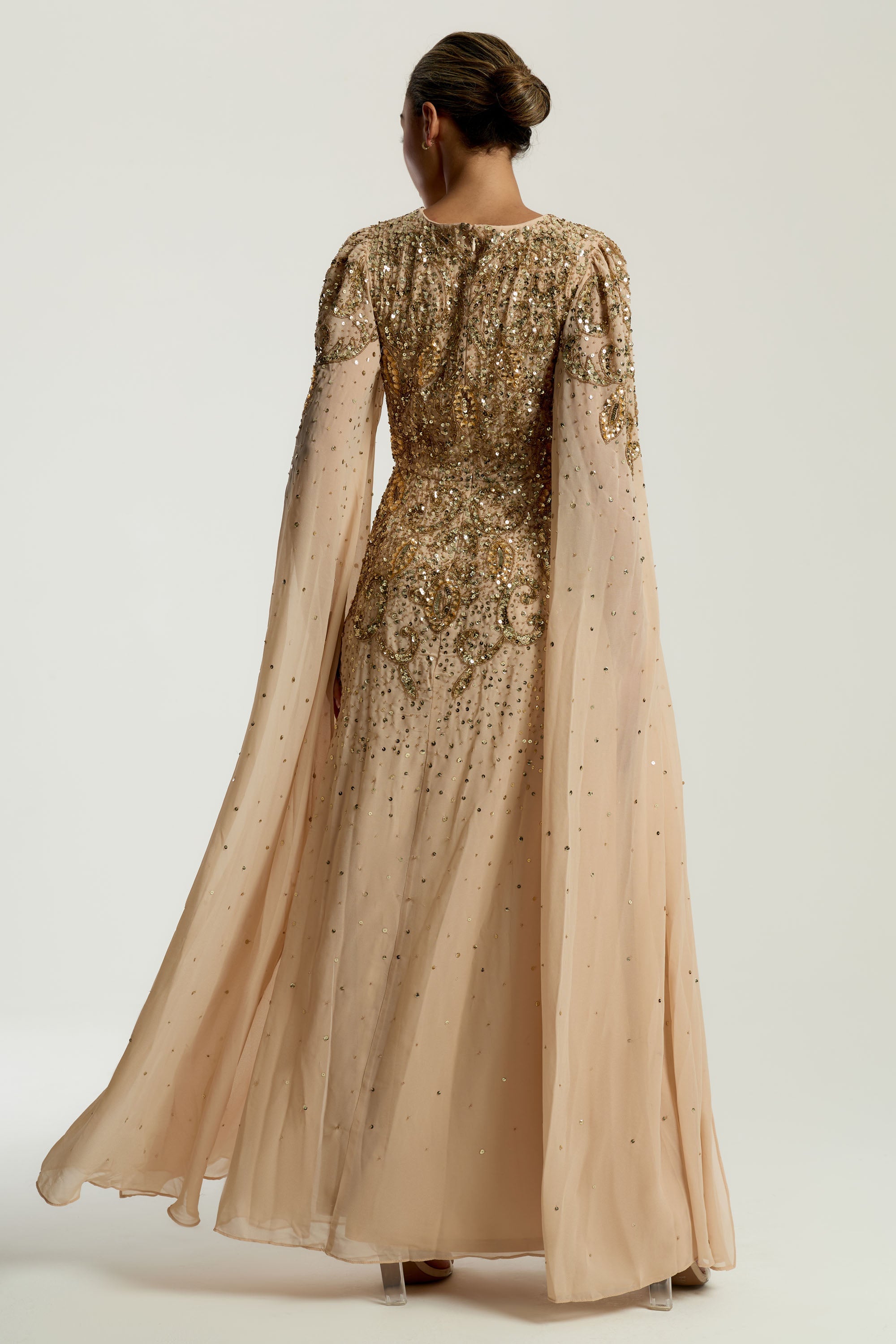 Donna gold embellished maxi dress with flowing cape sleeves, intricate beaded bodice and scattered sequins cascading to the hem.