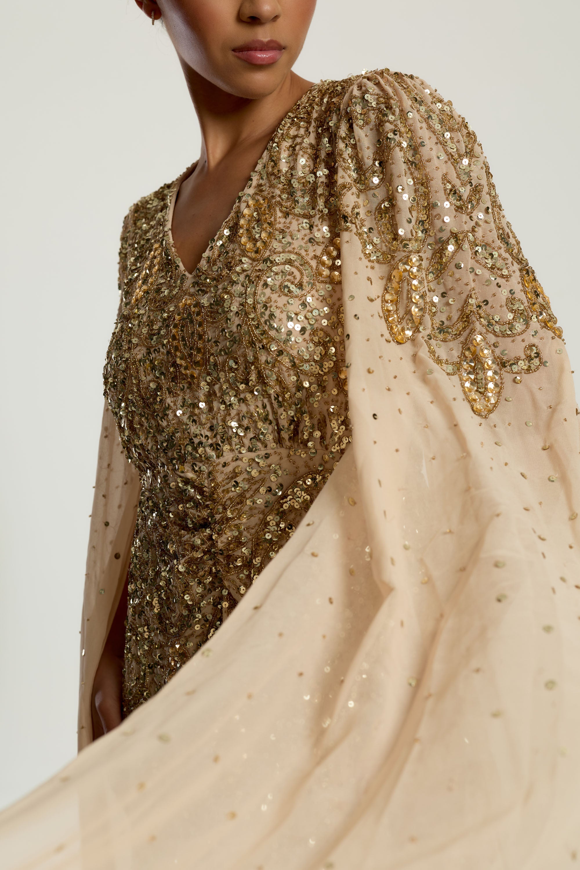 Donna gold embellished maxi dress with flowing cape sleeves, intricate beaded bodice and scattered sequins cascading to the hem.