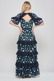 Jasmine navy maxi dress by Frock and Frill with floral embroidery, ruffled tiered skirt, and sheer flutter sleeves, styled for weddings and garden parties.