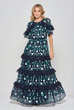 Jasmine navy maxi dress by Frock and Frill with floral embroidery, ruffled tiered skirt, and sheer flutter sleeves, styled for weddings and garden parties.