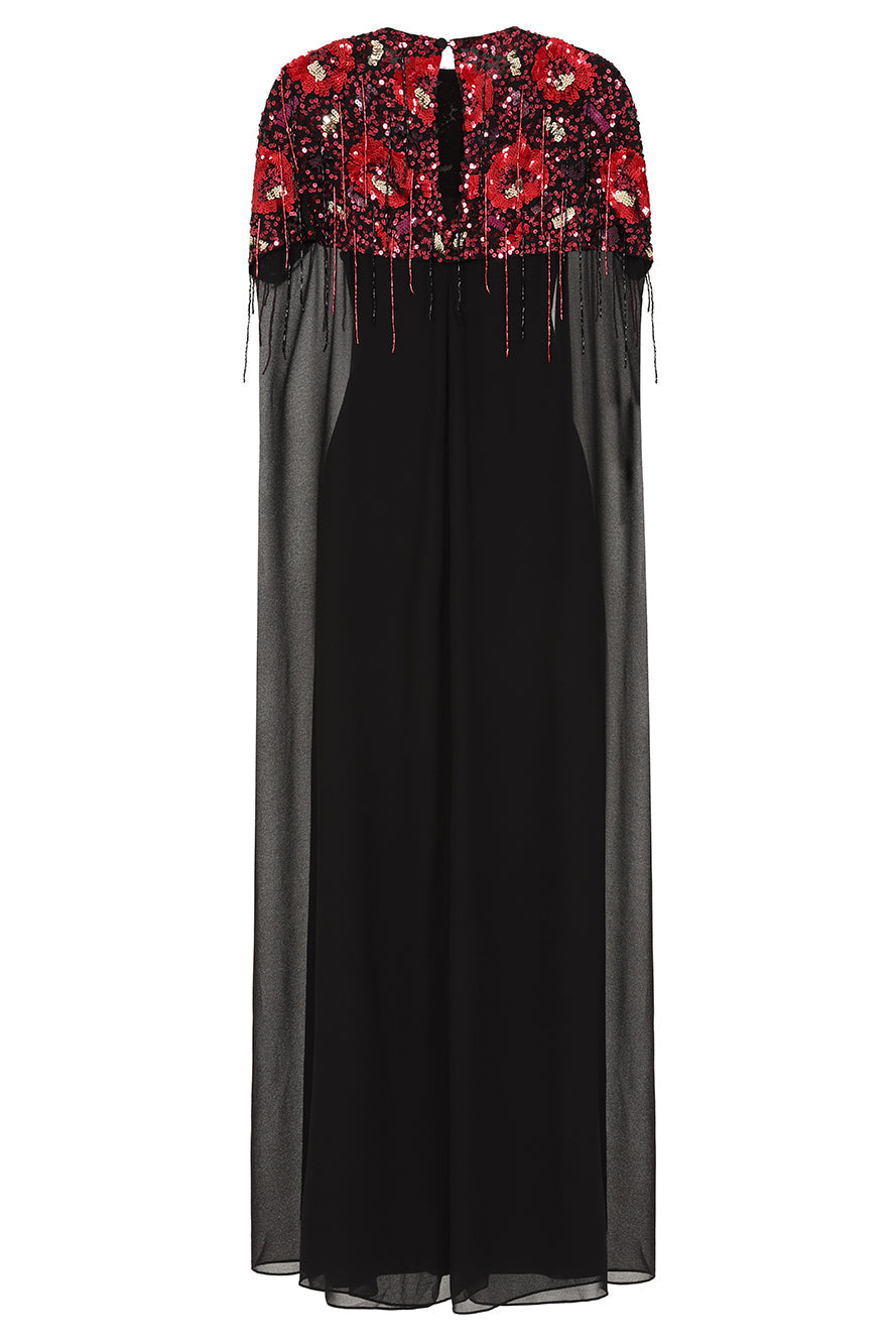 Elegant black maxi cape dress with a relaxed, fluid silhouette and a sheer flowing cape overlay that offers arm and shoulder coverage. The cape is decorated with deep red hand-sequinned floral motifs and cascading beaded tassels that add movement and spar