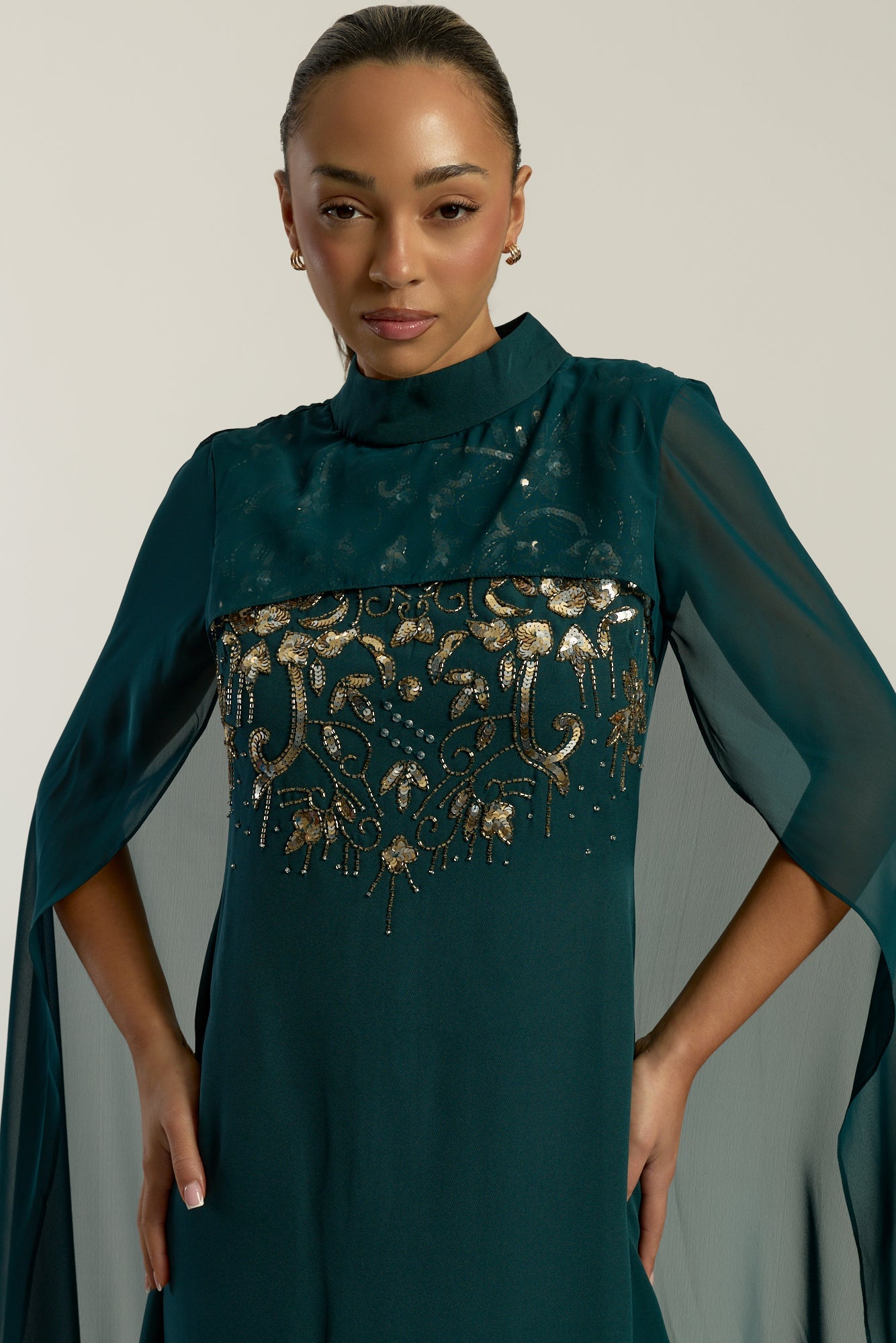 Frock and Frill Paloma Embellished Maxi Dress with cape detail, long sleeves, and flowing silhouette in rainforest green, perfect for weddings and evening events.