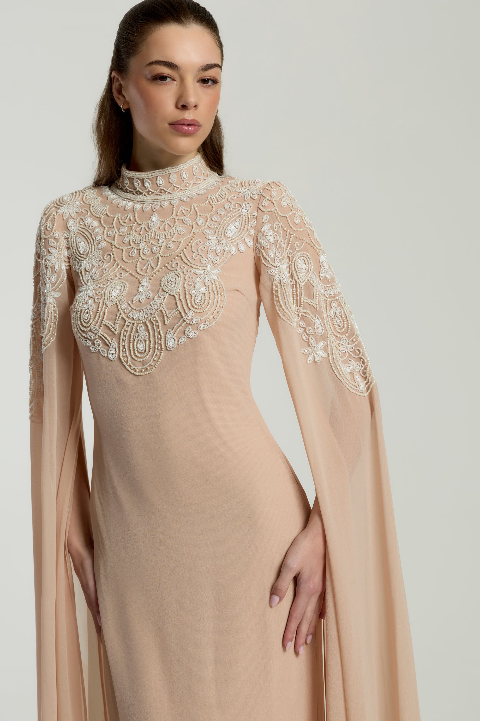 Penelope blush cape maxi dress with white embellishments on bodice and cape sleeves, modest formal dress for weddings and spring occasions