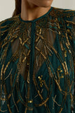 Green embellished maxi dress with flowing pleated skirt and detachable sheer cape overlay, featuring gold bead detailing and an elegant V-neck silhouette for occasion wear.