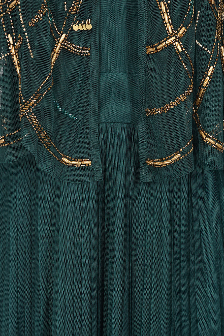 Green embellished maxi dress with flowing pleated skirt and detachable sheer cape overlay, featuring gold bead detailing and an elegant V-neck silhouette for occasion wear.