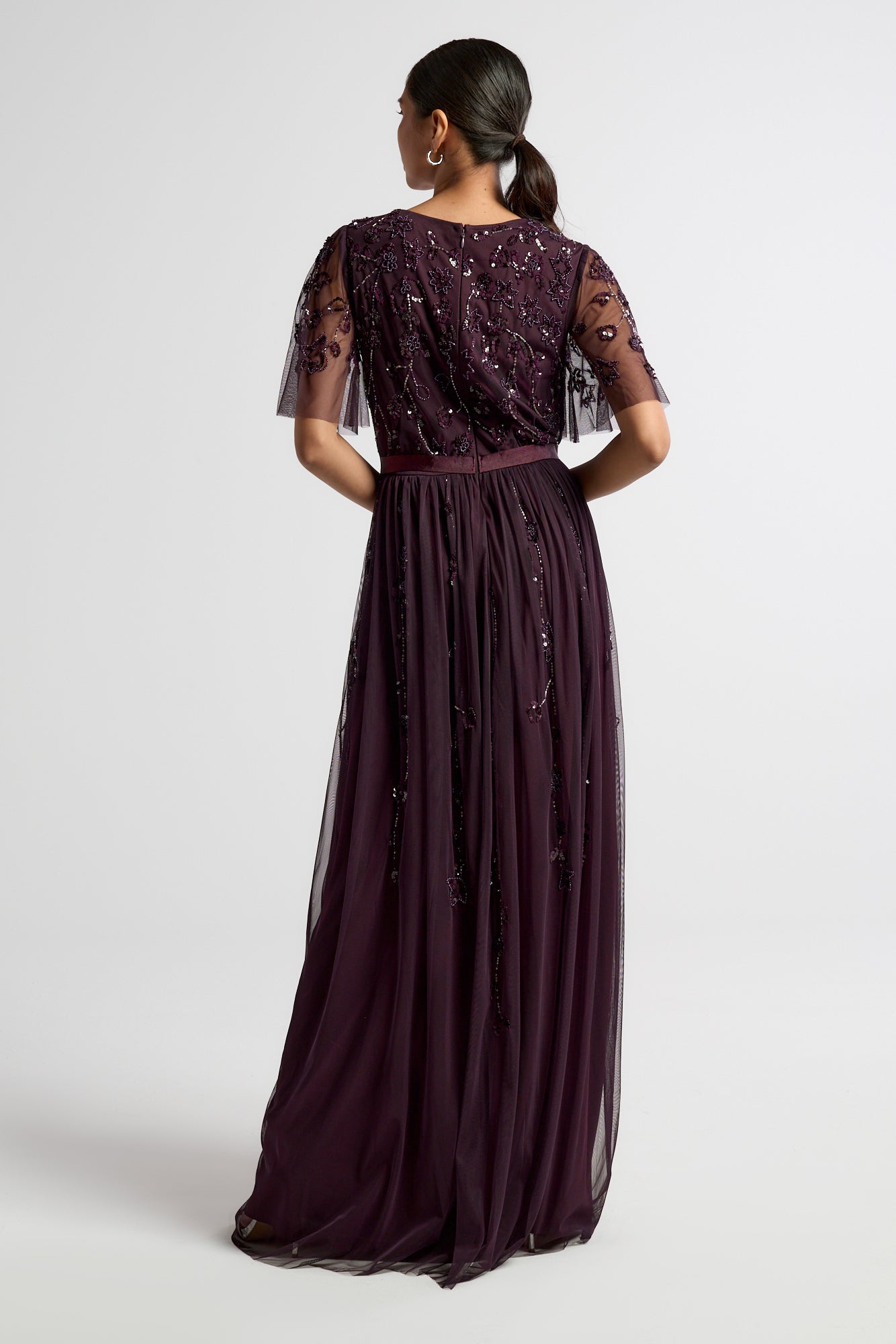 Talia dark purple embellished maxi dress with long sleeves, beaded bodice, and flowing skirt, suitable for bridesmaids or formal occasions.