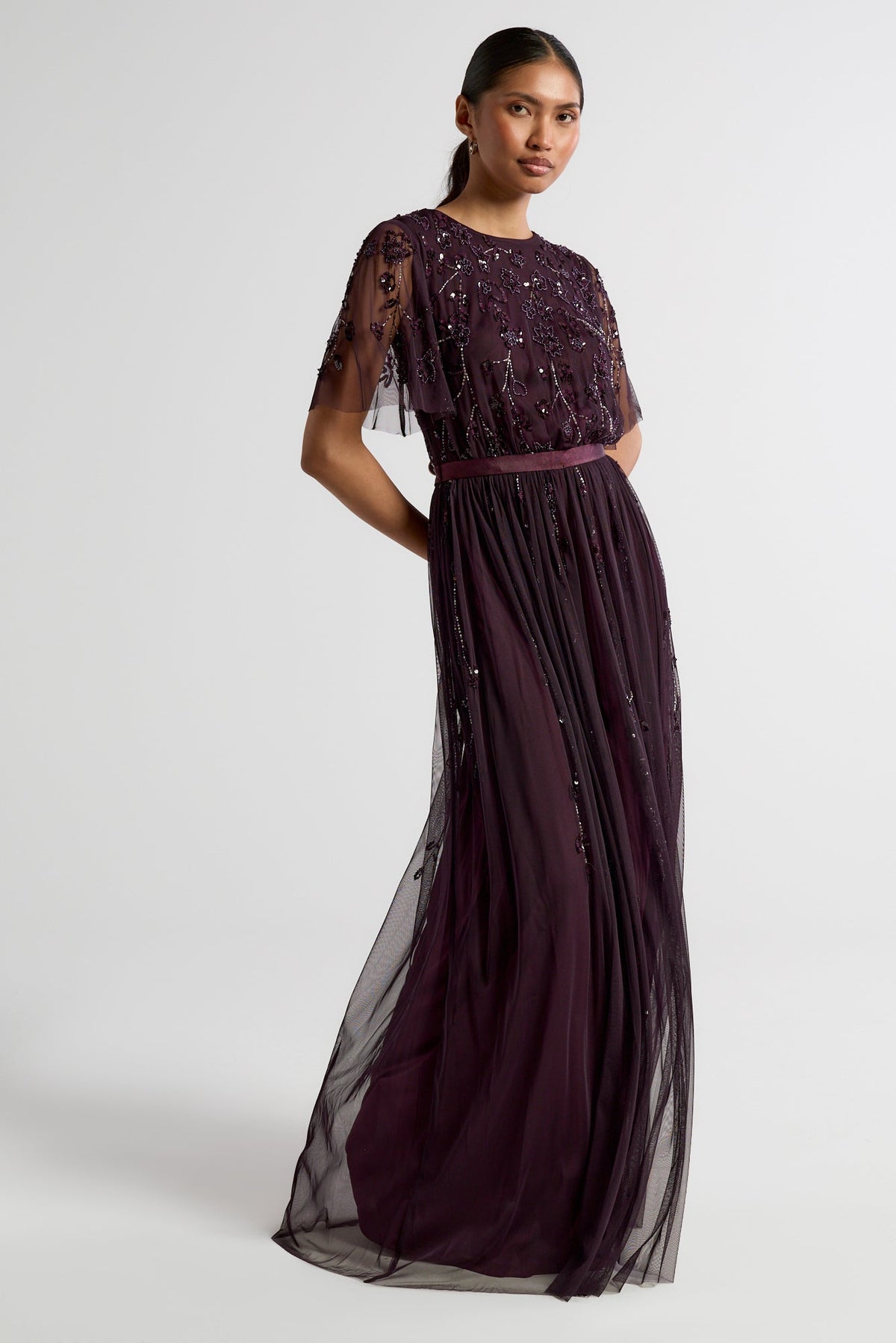 Talia dark purple embellished maxi dress with long sleeves, beaded bodice, and flowing skirt, suitable for bridesmaids or formal occasions.