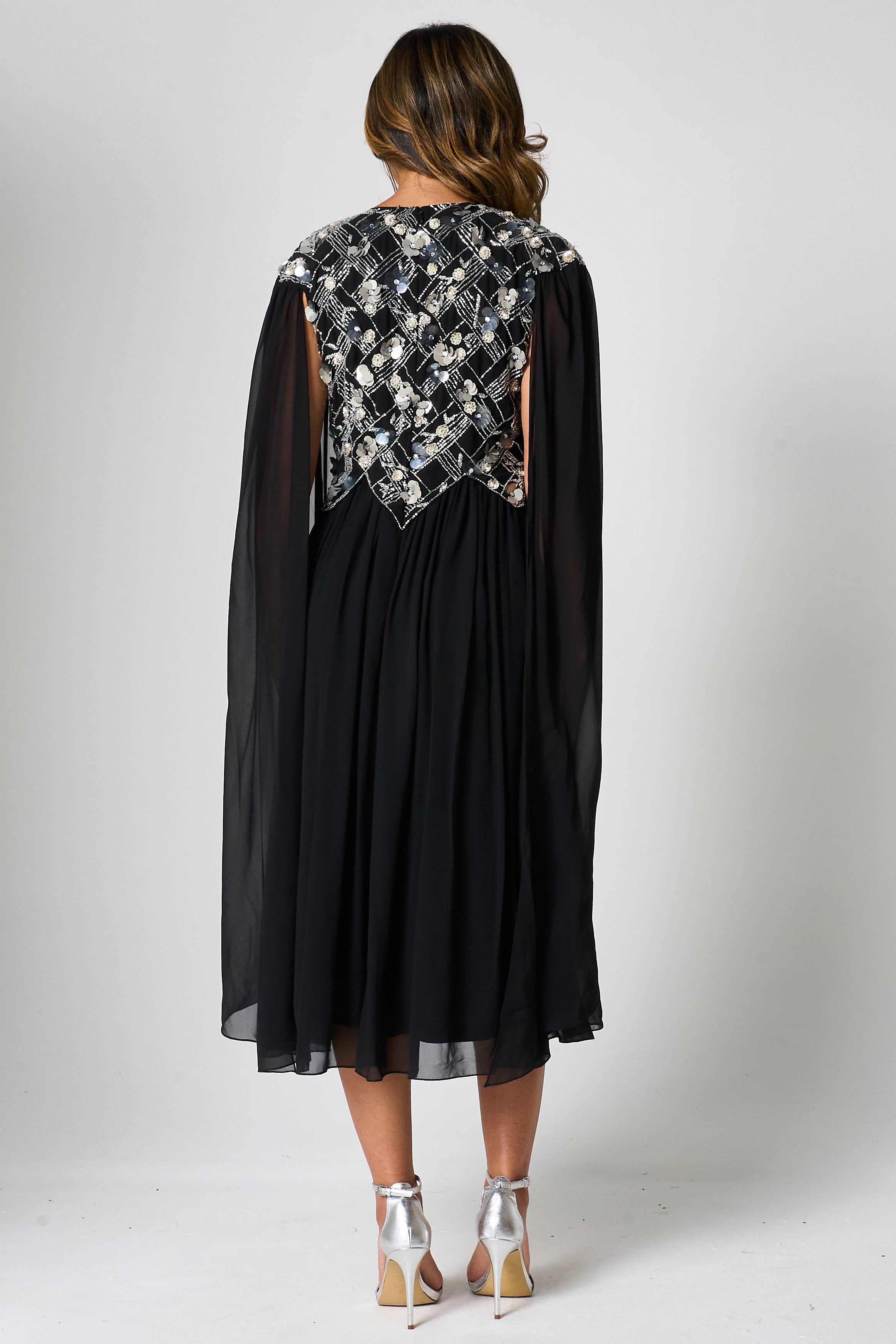 Una black embellished cape sleeve midi dress by Frock and Frill with silver bodice detailing, high neckline and flared skirt designed for elegant occasion wear styling