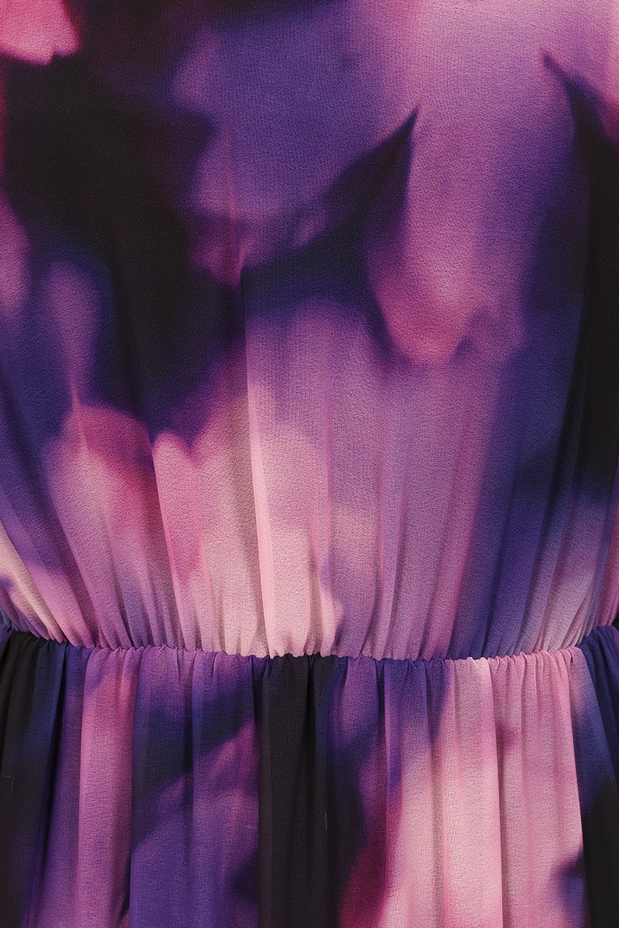 Black floral print maxi dress with high neckline, sheer long sleeves, tiered skirt and keyhole back detail displayed on a model.